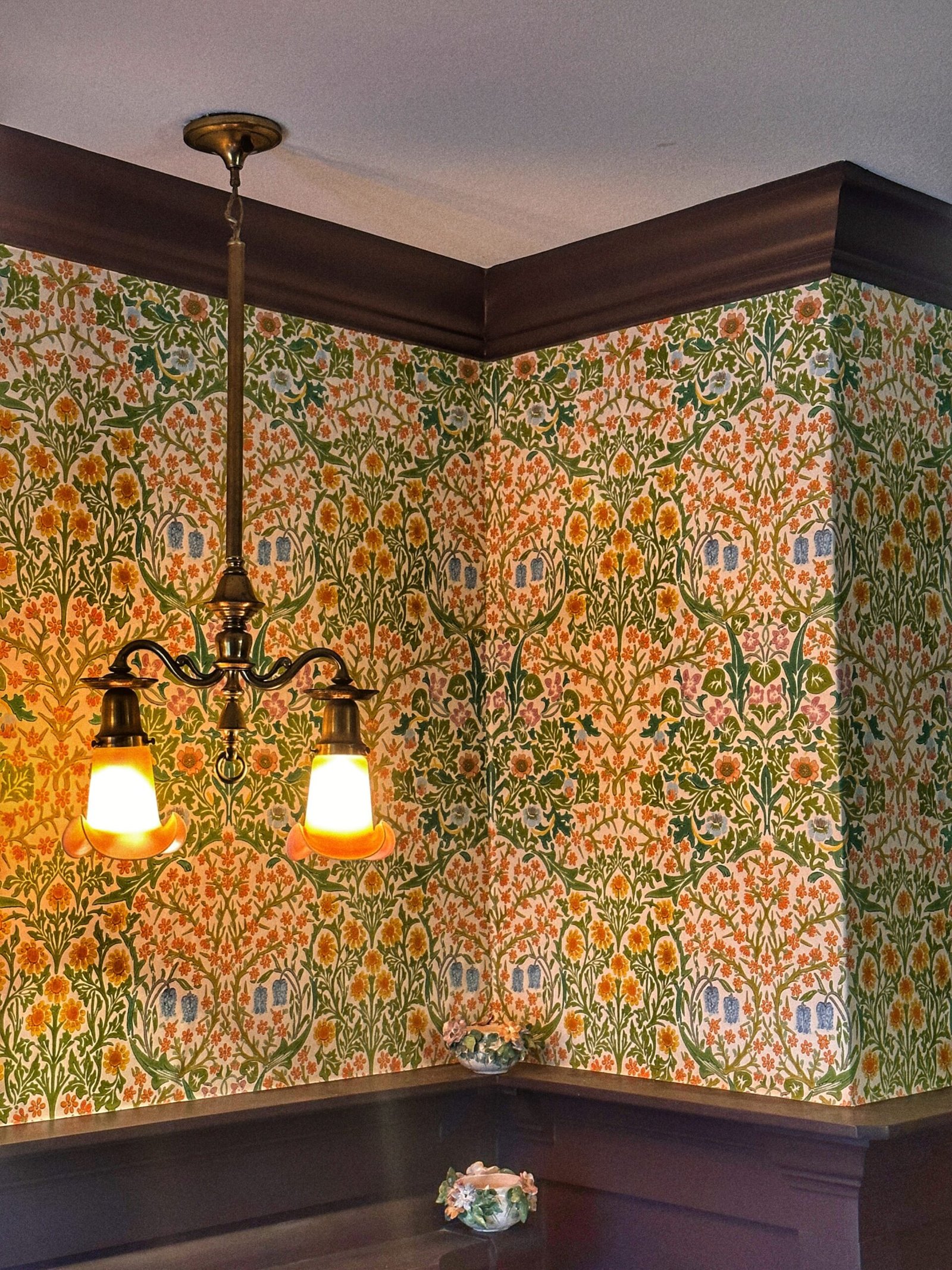 Botanical wallpaper bedroom detail with warm light